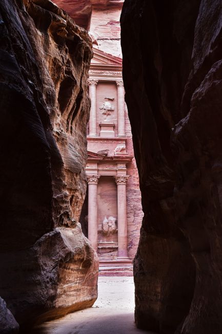 A breathtaking view of Al-Khazneh Treasury through rock formations in Petra, Jordan.