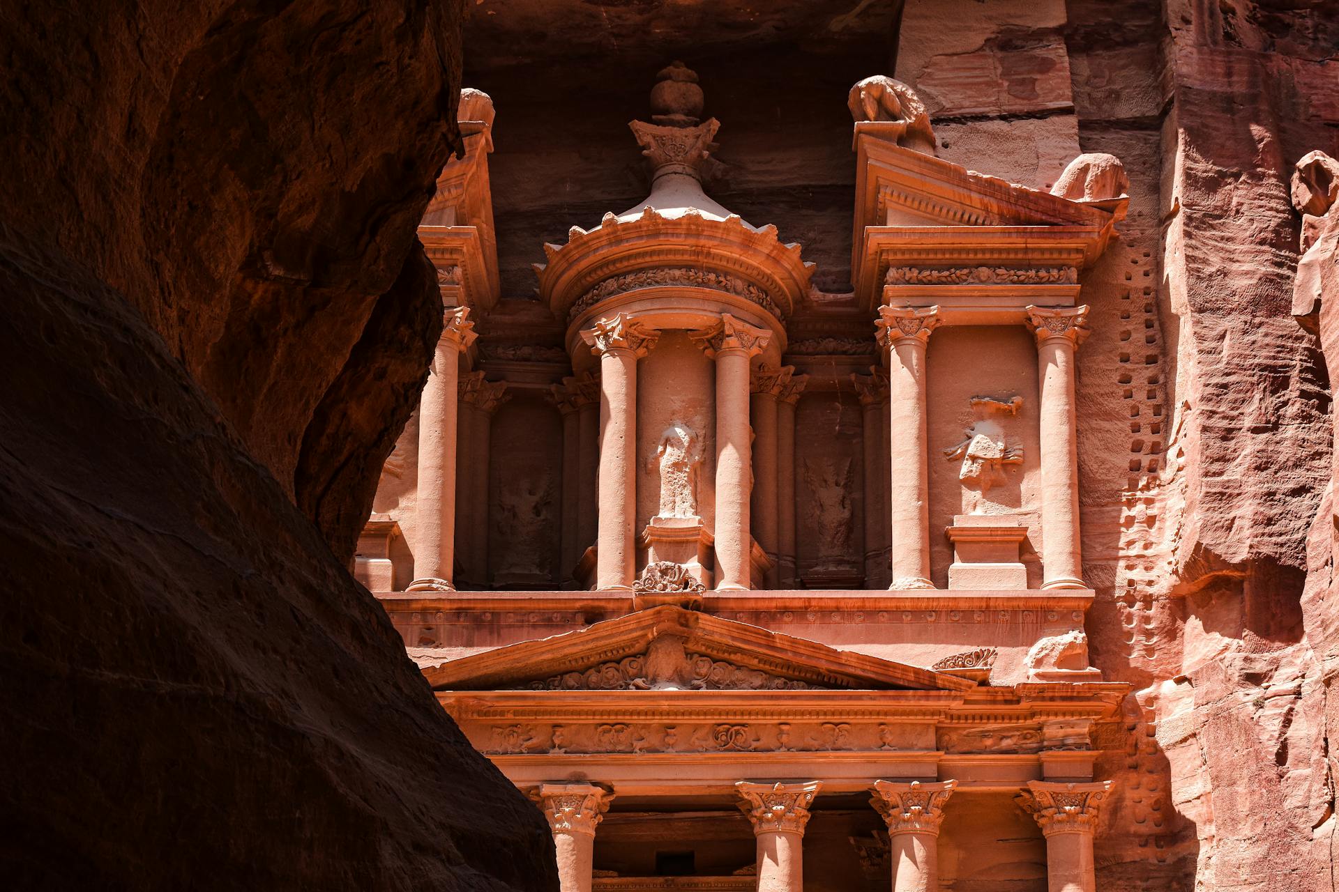 Iconic view of The Treasury in Petra, an ancient Nabatean city carved in pink sandstone rock.