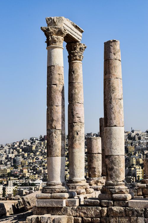 Free View of the iconic Temple of Hercules ruins contrasting against the bustling cityscape of Amman. Stock Photo