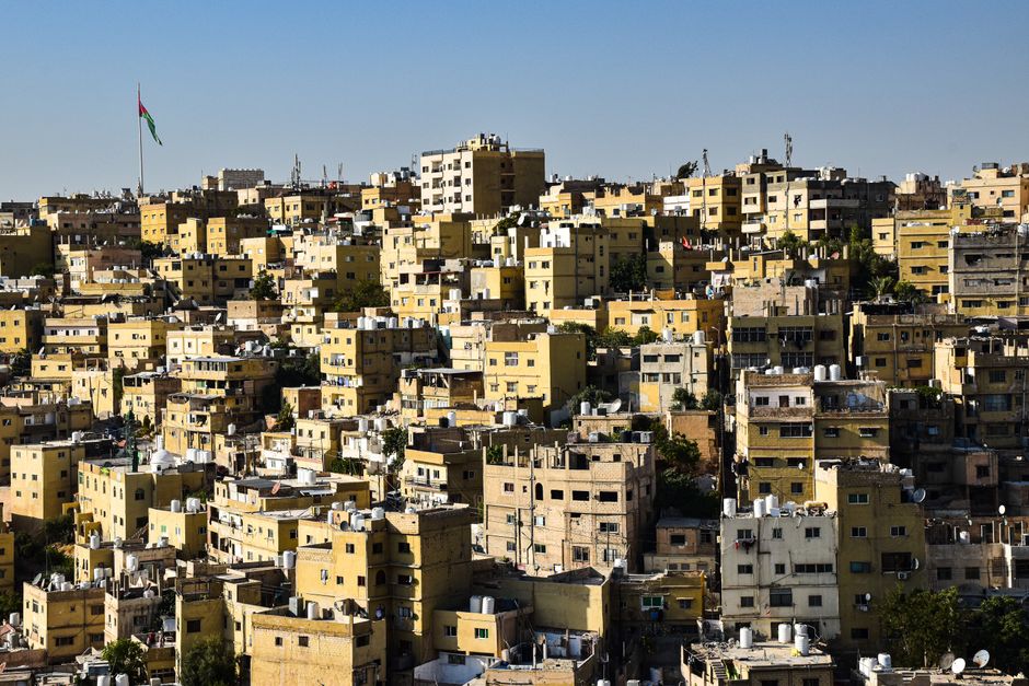 A yellow taxi driving on a bustling street in Amman, Jordan