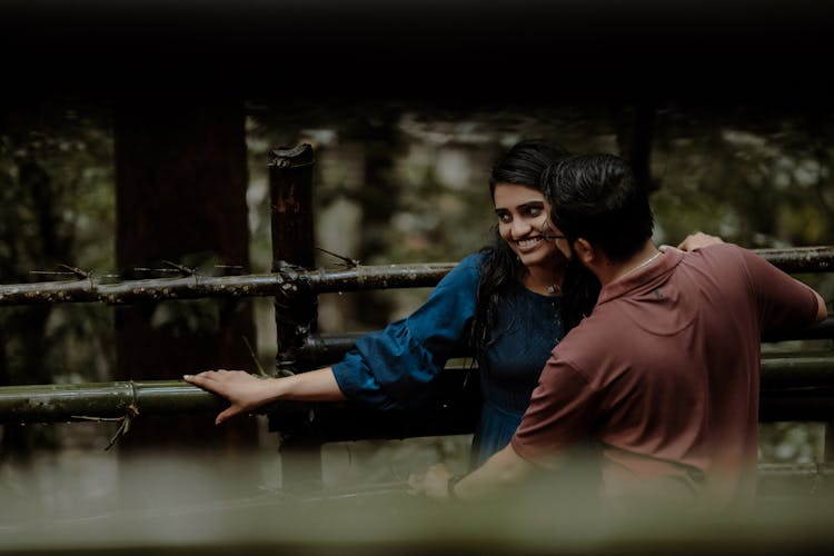 Smiling Couple Standing Together By Railing