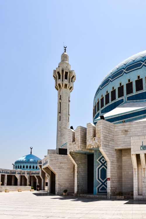 Free A beautiful side view of the King Abdullah I Mosque in Amman, featuring its iconic minaret and blue dome under a clear sky. Stock Photo