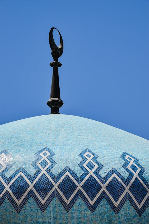Free The distinctive dome of King Abdullah I Mosque adorned with blue tiles against a clear sky.وسط عمّان