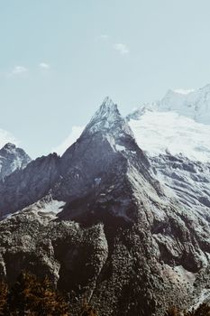 Breathtaking view of towering snow-capped mountains with clear blue sky.
