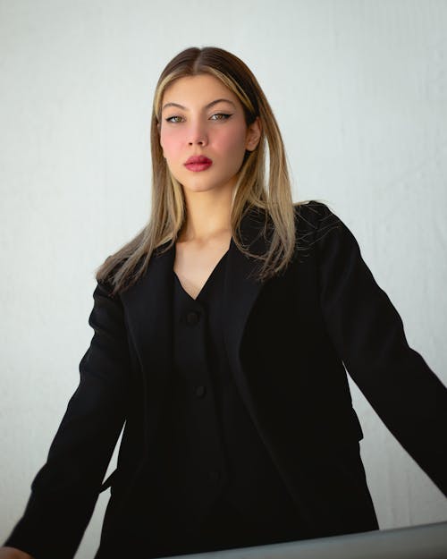 Blonde Wearing Black Clothing Posing against a White Wall