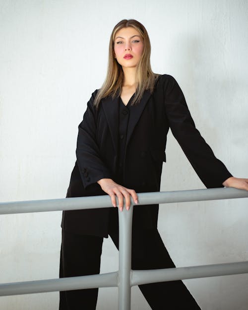 Young Model Wearing Black Clothing, Leaning against a Gray Balustrade