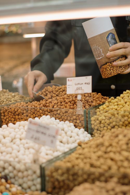 Free Close-up of hands selecting nuts at a Turkish street market. Stock Photo