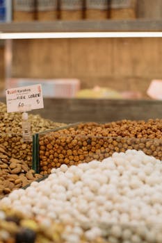 Close-up of various nuts and snacks at a Turkish market with a price sign.