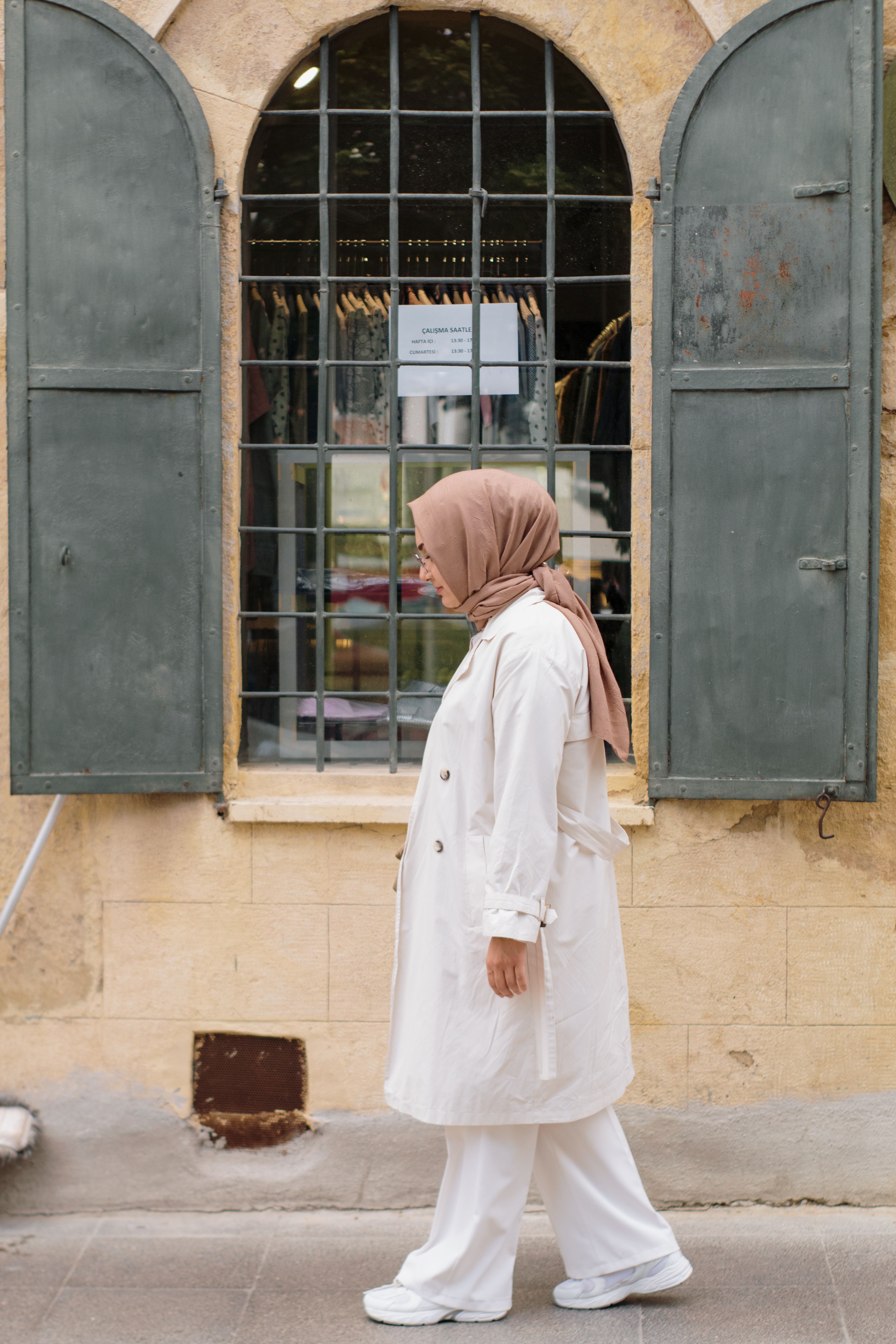 Woman in Hijab and White Coat Walking Along Sidewalk · Free Stock Photo