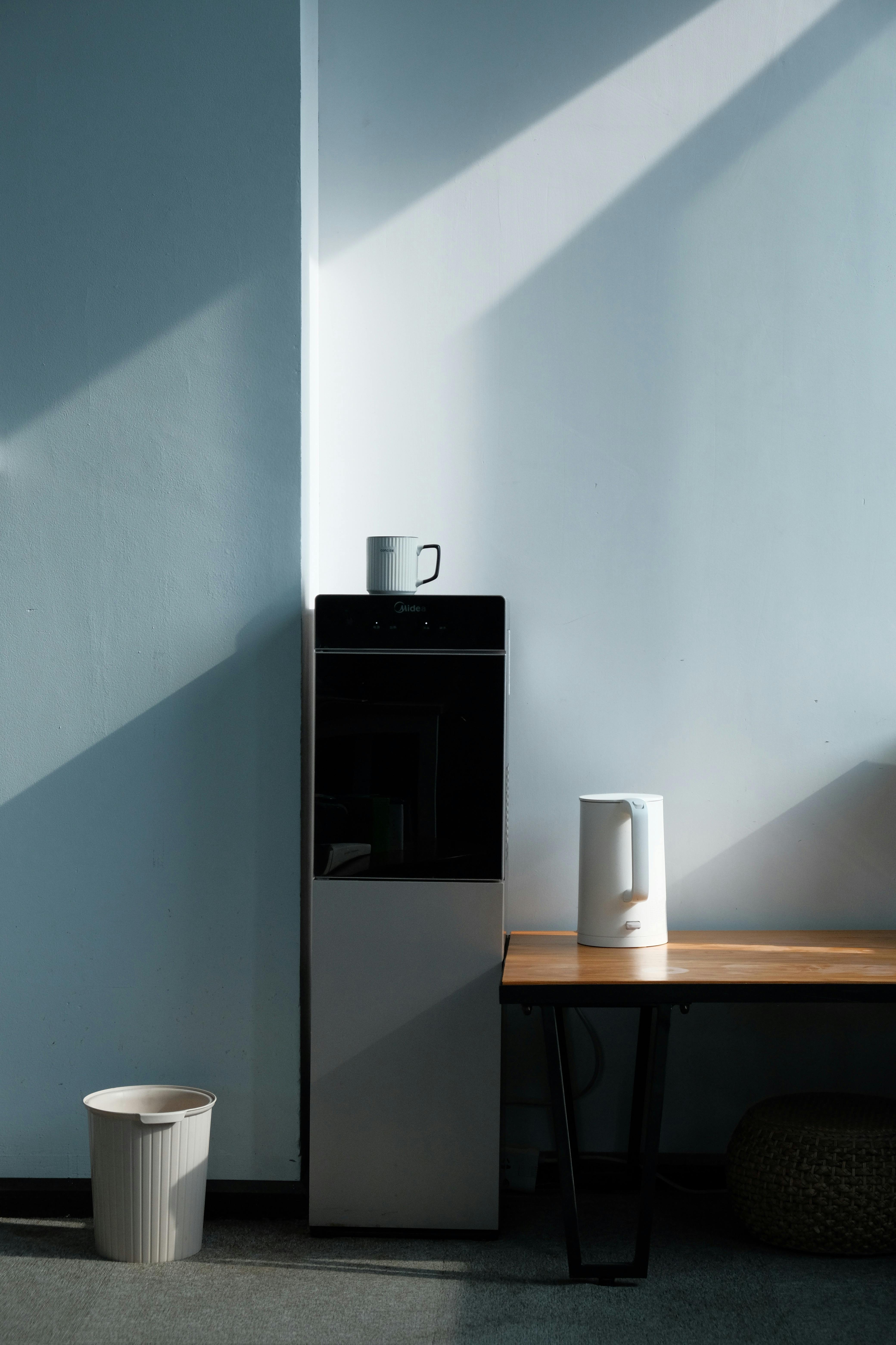 Simple and elegant minimalist design featuring a kettle on a table with natural light.