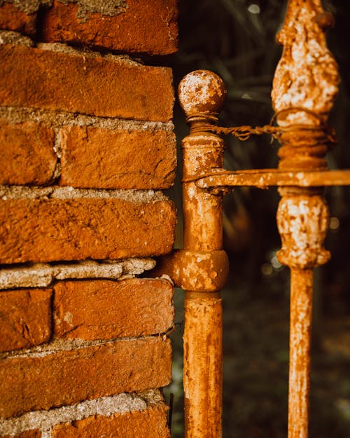 Close-up of a Brick Wall and Rusty Metal Poles