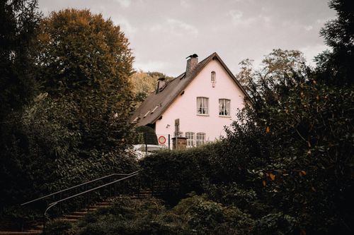 Free A quaint rural cottage nestled among vibrant autumn foliage, creating a serene and picturesque scene. Stock Photo
