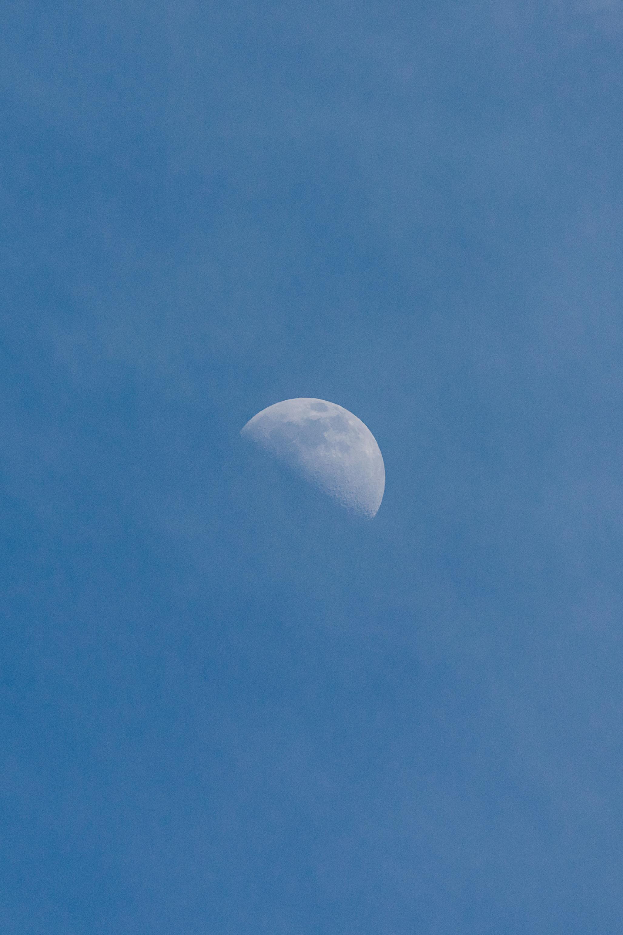 Beautiful view of the moon against a clear blue sky in Berlin, Germany.