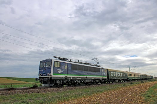 Locomotive traveling through scenic rural fields in Germany, showcasing transportation and countryside views.