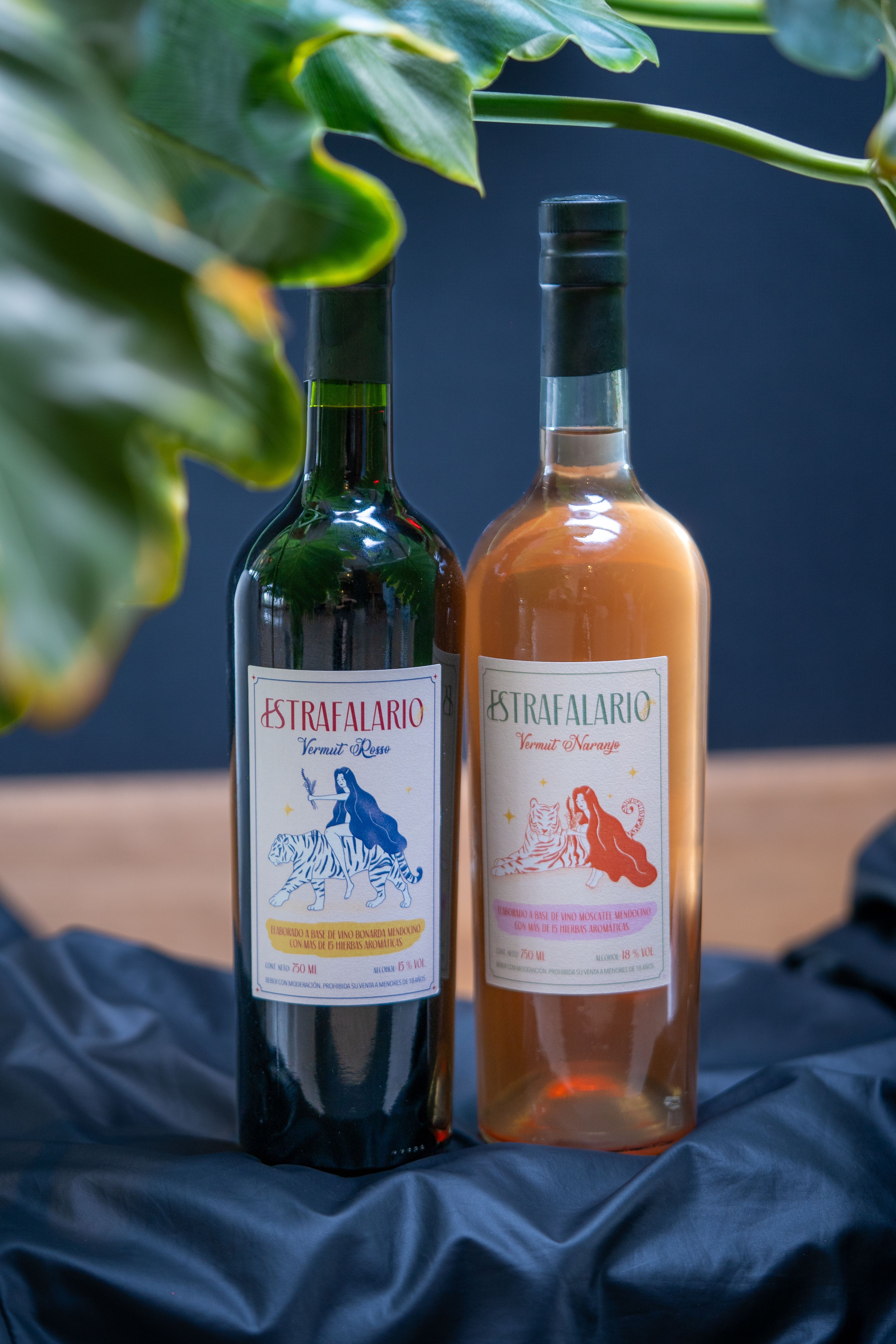 Two wine bottles with artistic labels displayed elegantly indoors.