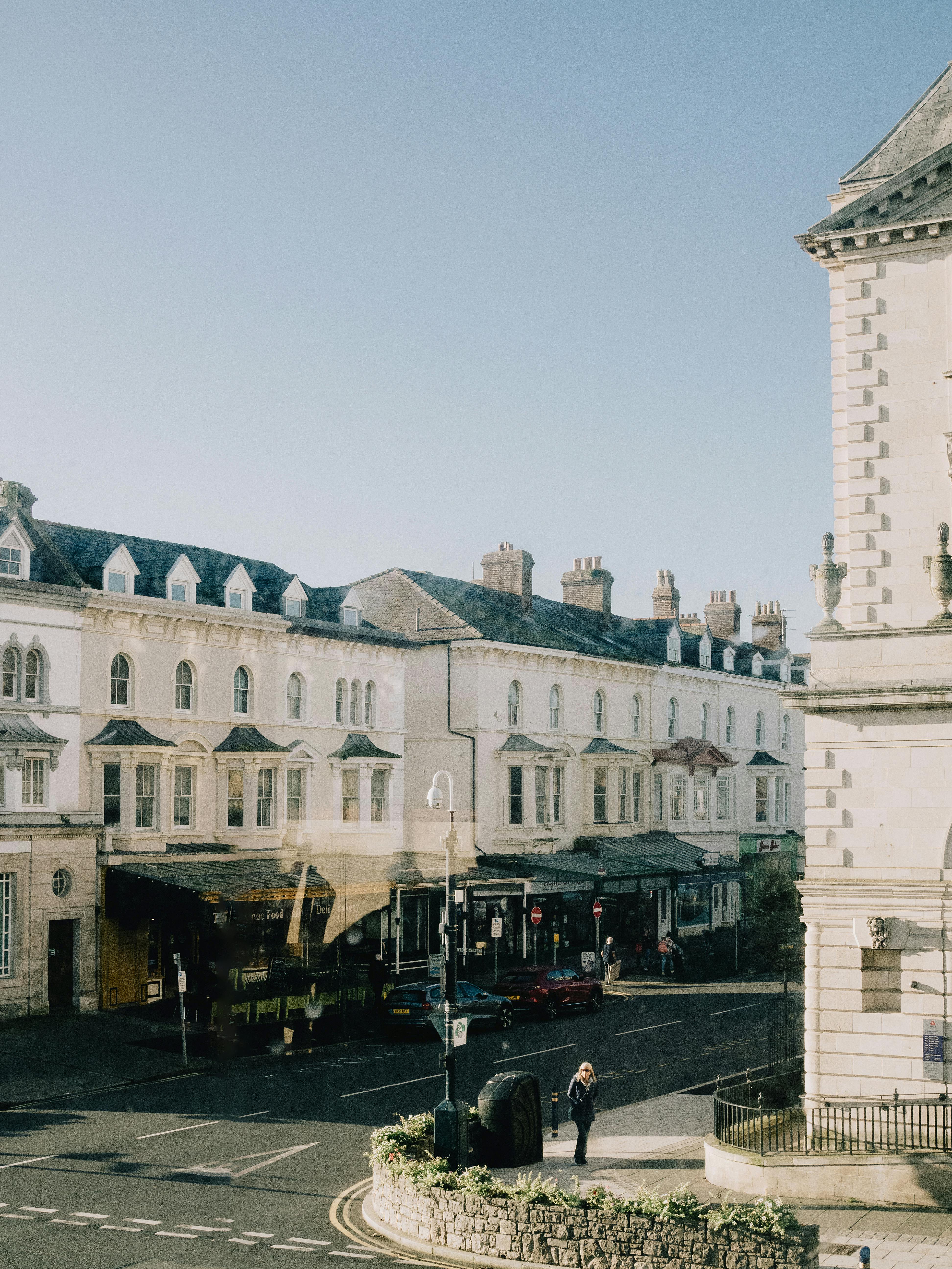 Free Sunlit street scene in Llandudno, Wales, showcasing historic architecture and a bustling atmosphere. Stock Photo