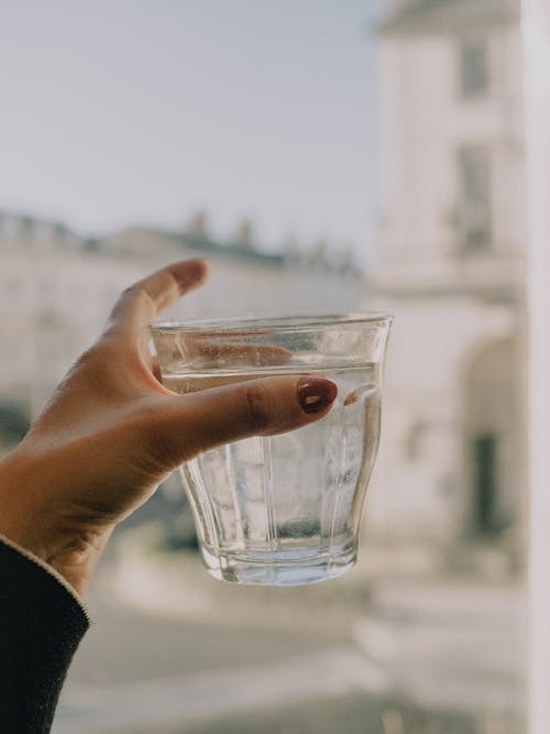 Hand of a Woman Holding a Glass of Water