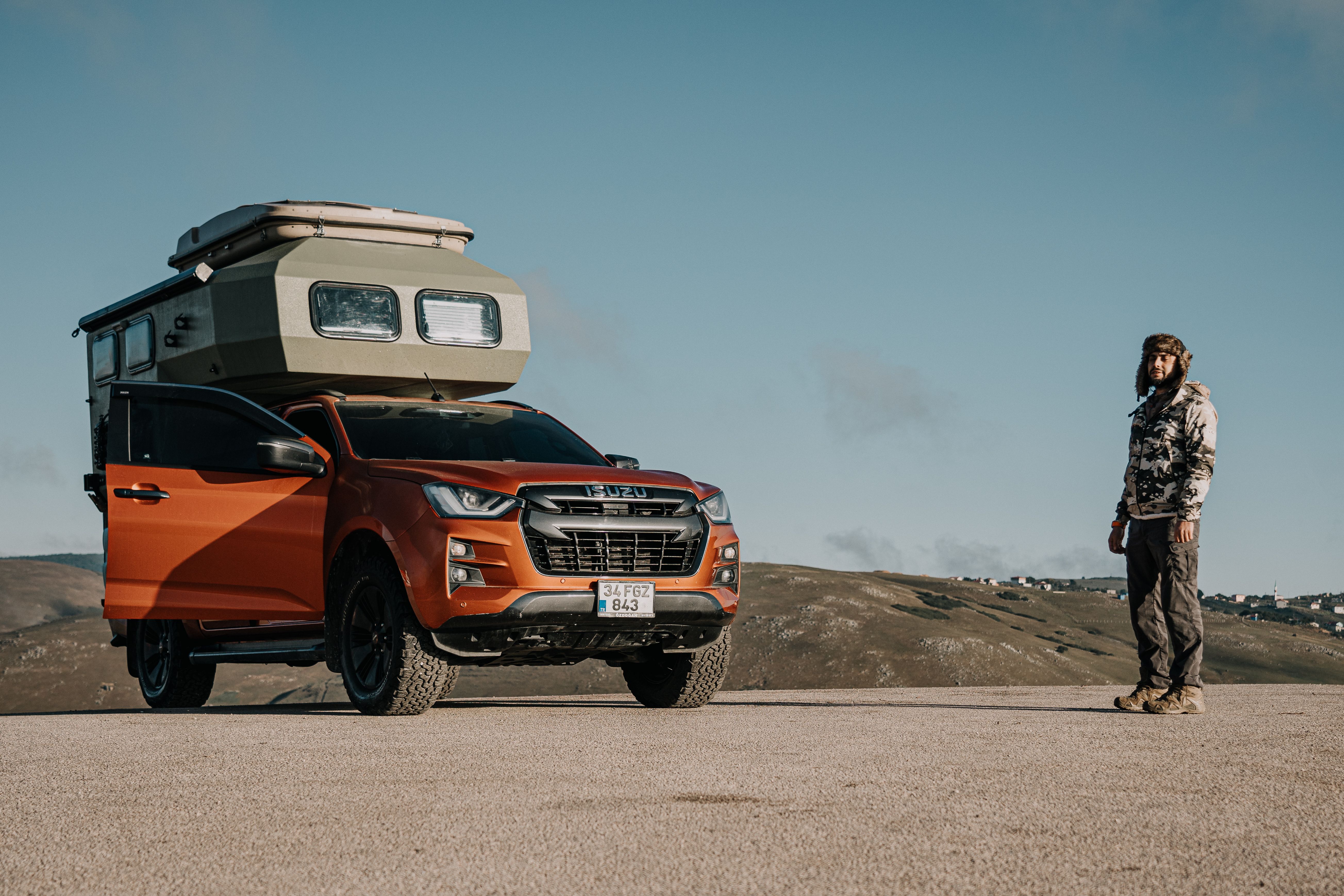 A rugged camper truck with a man in outdoor gear, set against the scenic Ordu landscape.