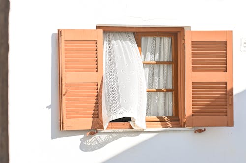 Shutters on Windows with White Curtains