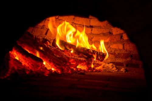 Free Close-up of a vibrant fire burning in a brick fireplace, exuding warmth and coziness. Stock Photo
