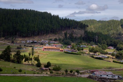 Tranquil rural scene with bungalows, forest, and hills in Cajamarca, Peru.