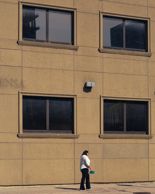 Woman in Front on an Apartment Building in Sunlight 