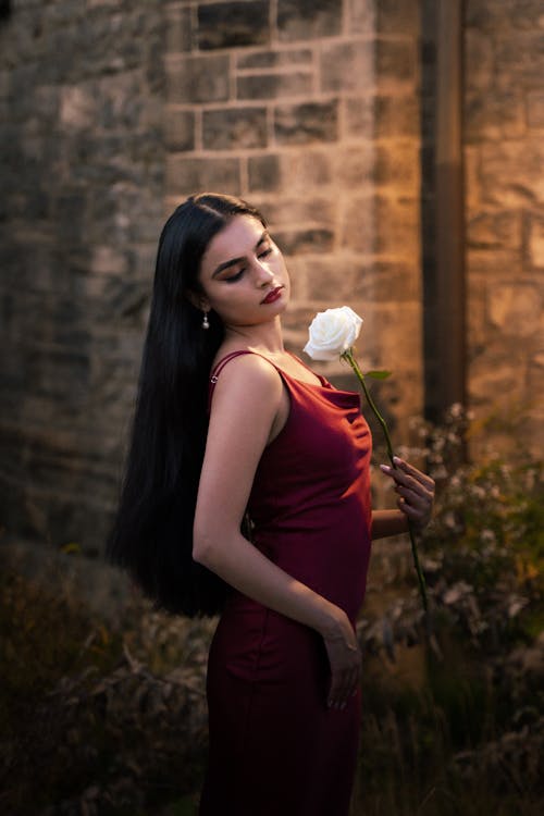 Young Model in a Silk Red Dress Holding a White Rose