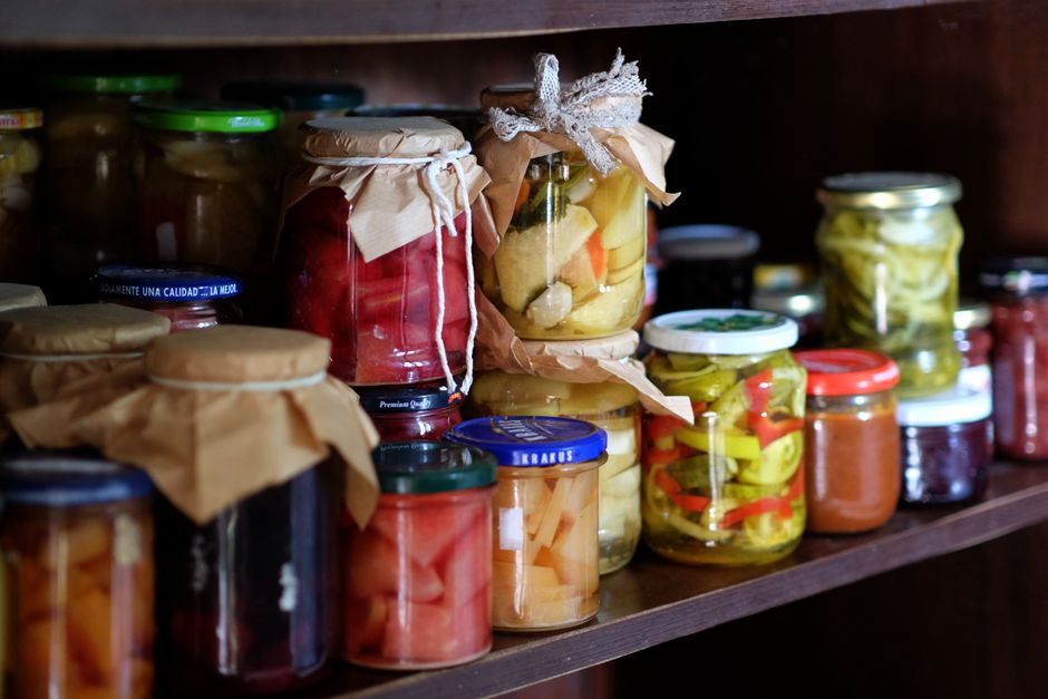 Conserve de casă pe raft de lemn rustic, legume și murături care pot reprezenta risc de botulism dacă nu sunt preparate corect