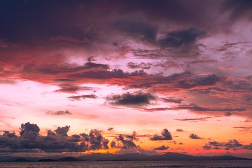 Free Beautiful view of a dramatic sunset over the sea with colorful clouds. Stock Photo