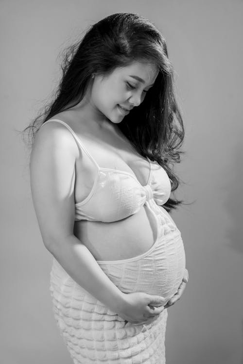 Smiling, Pregnant Model in White Dress