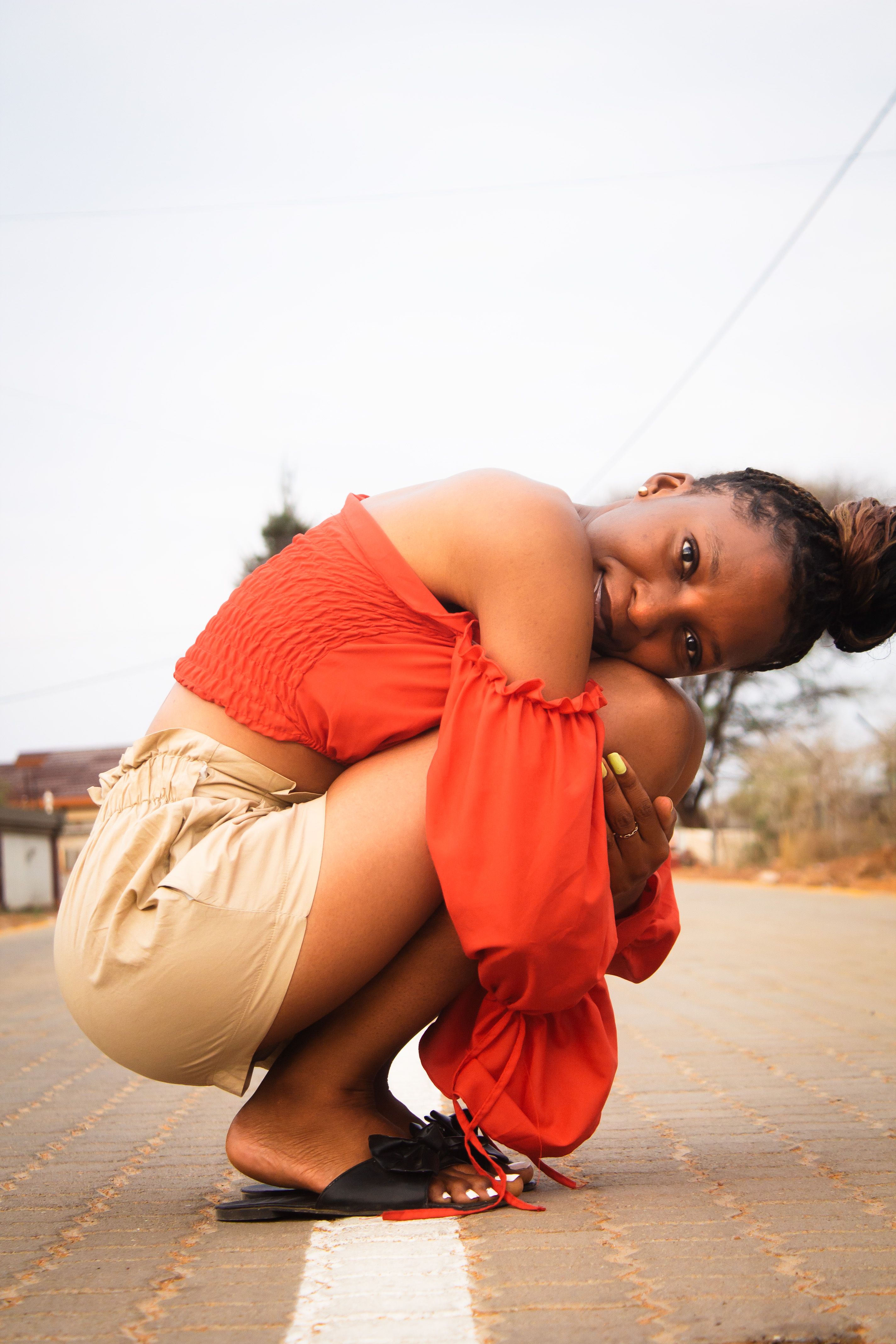 Model Squatting on Pavement · Free Stock Photo