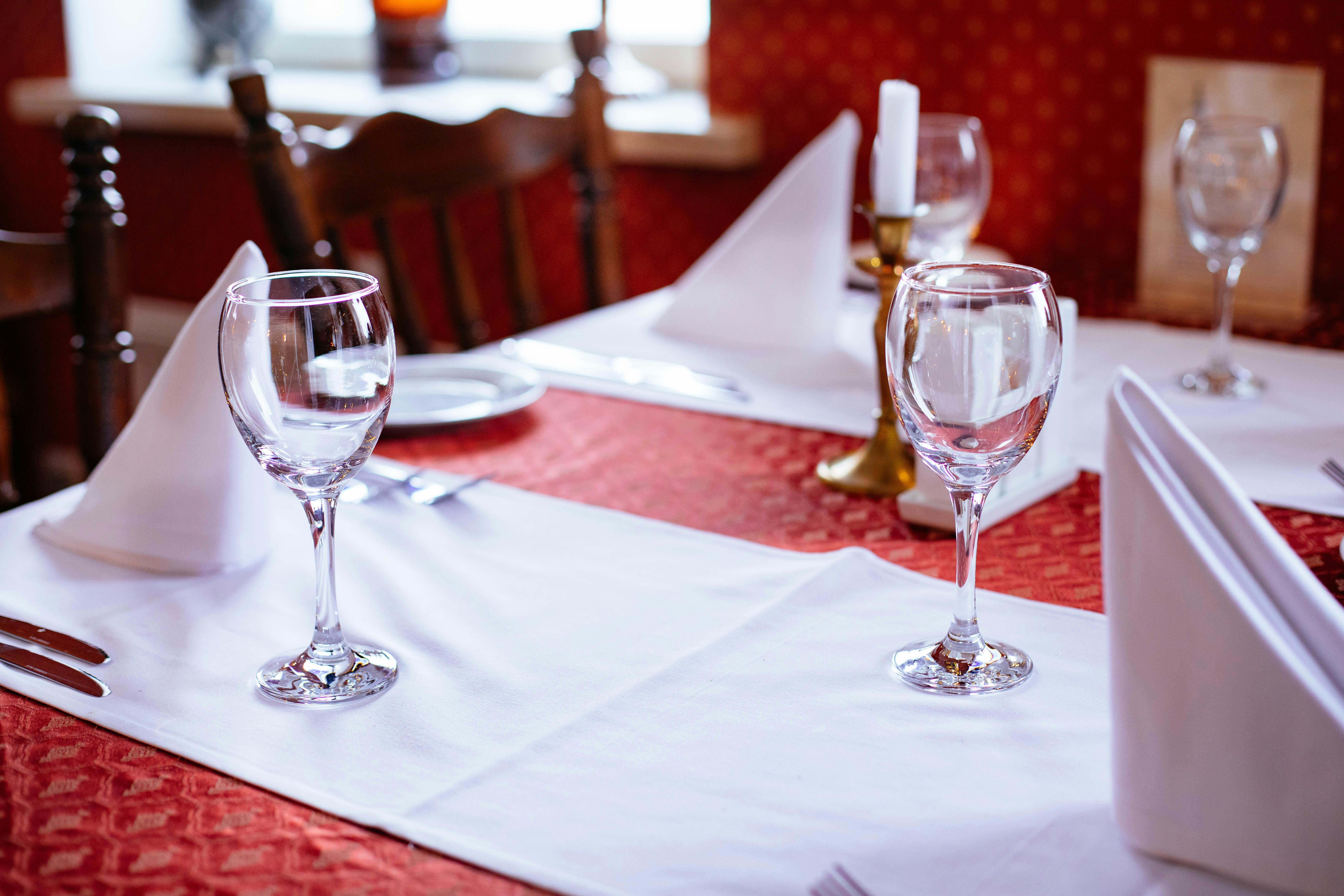 Sophisticated table setting with wine glasses and candles in a cozy restaurant.