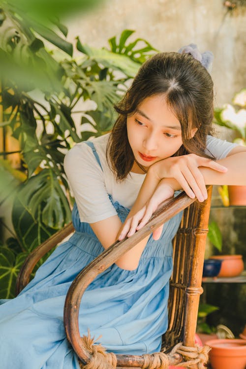 Young Woman Sitting among Plants