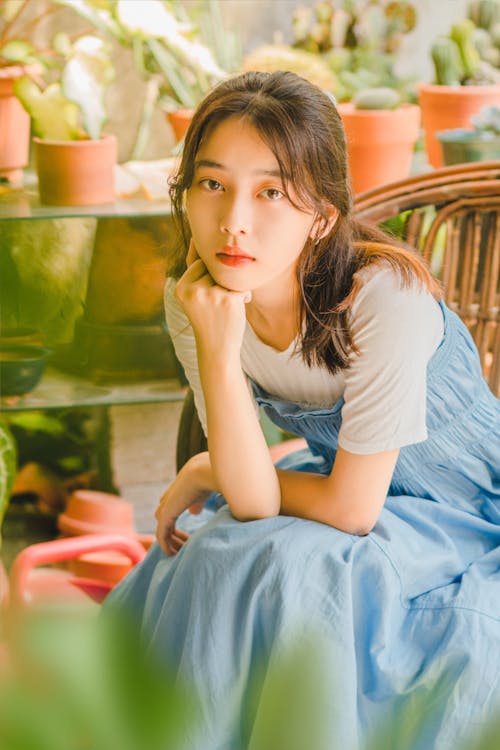 Young Woman Sitting among Plants