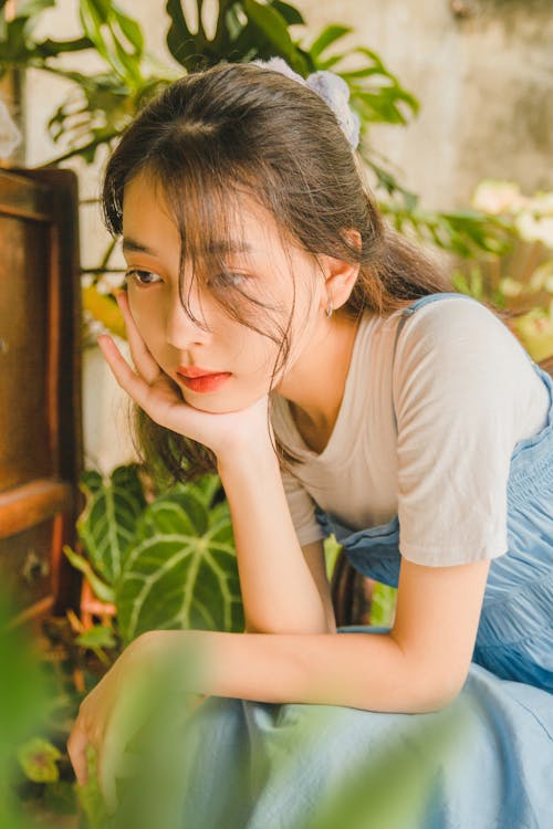 Young Woman Sitting among Plants