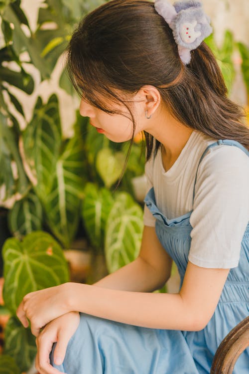 Young Woman Sitting among Plants