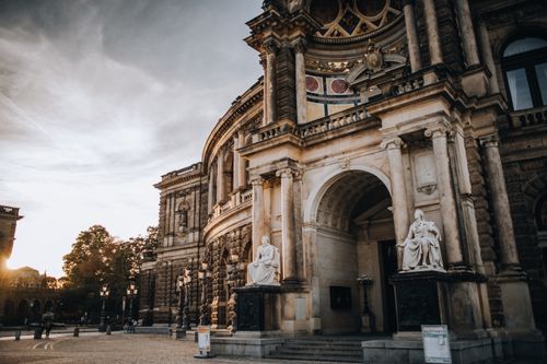 Free Ornate historical building facade with statues and detailed entrance in urban setting. Stock Photo