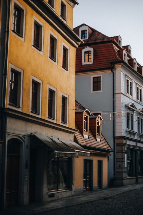 Free Scenic view of a quiet European street lined with historic buildings at dusk. Stock Photo