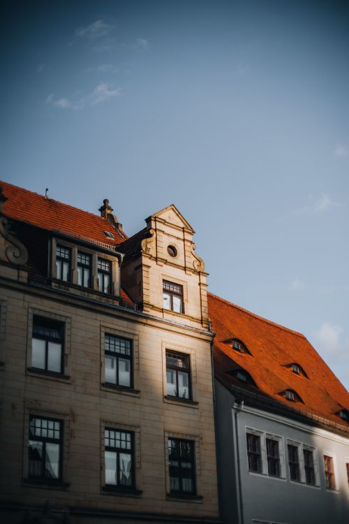 Free Elegant historic tenement with distinct red rooftops captured at golden hour. Stock Photo