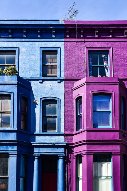 A vibrant display of blue and purple townhouses in an urban setting of London.