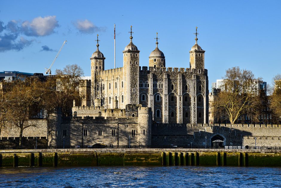 Historic Tower of London under a clear sky with tourists