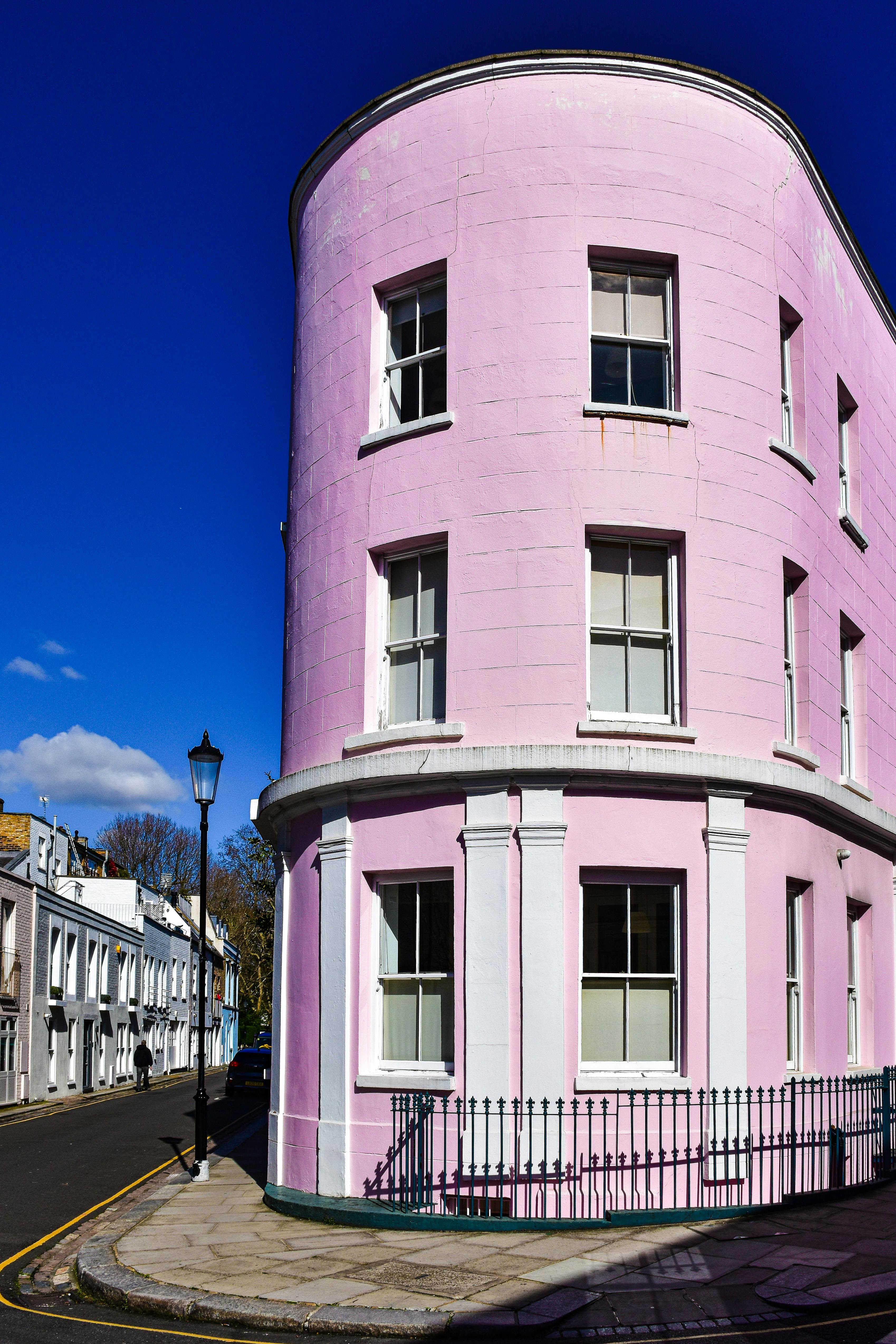Free Bright pink building facade on a Notting Hill street corner in London, under a clear blue sky. Stock Photo