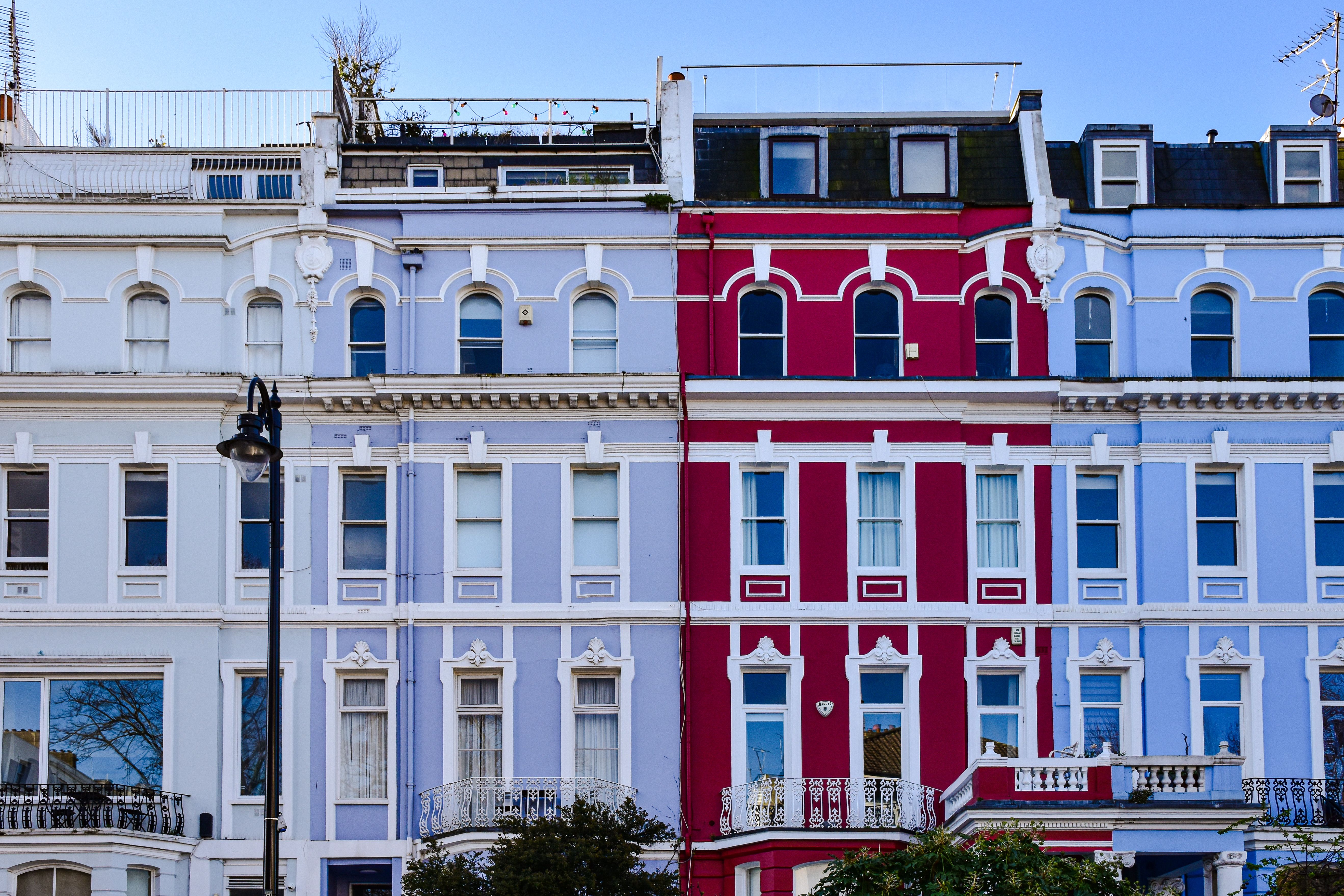 Charming and colorful facade of terraced houses in Notting Hill, London.