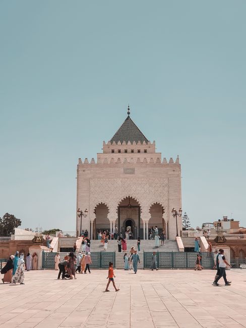A view of the Hassan Tower in Rabat, Morocco, with tourists walking around in a sunny summer day.