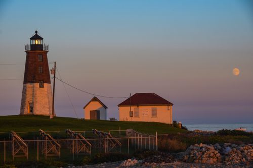 Free Beautiful evening scene of Point Judith Lighthouse with the moonrise over Narragansett, RI coast. Stock Photo