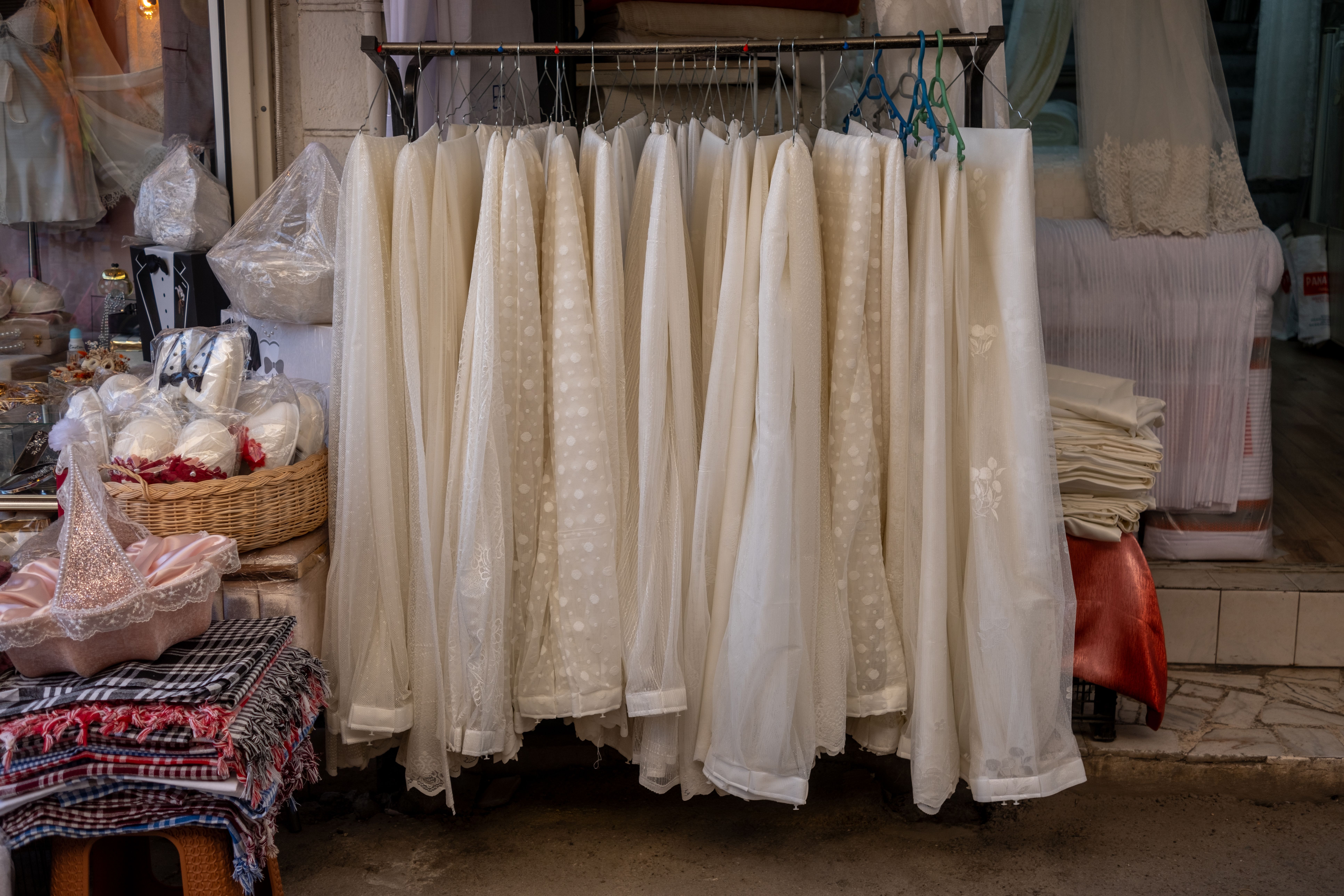 Sélection de tissus blancs haut de gamme, dentelles et soies sur un présentoir de boutique