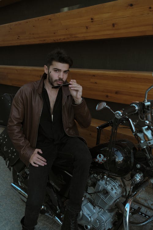 Model in Jacket and Sunglasses Sitting on Motorbike