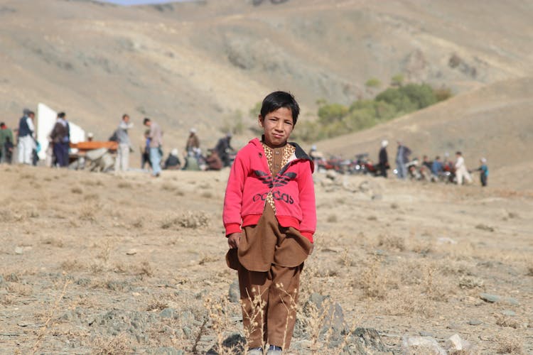 Boy In Hoodie On Grassland