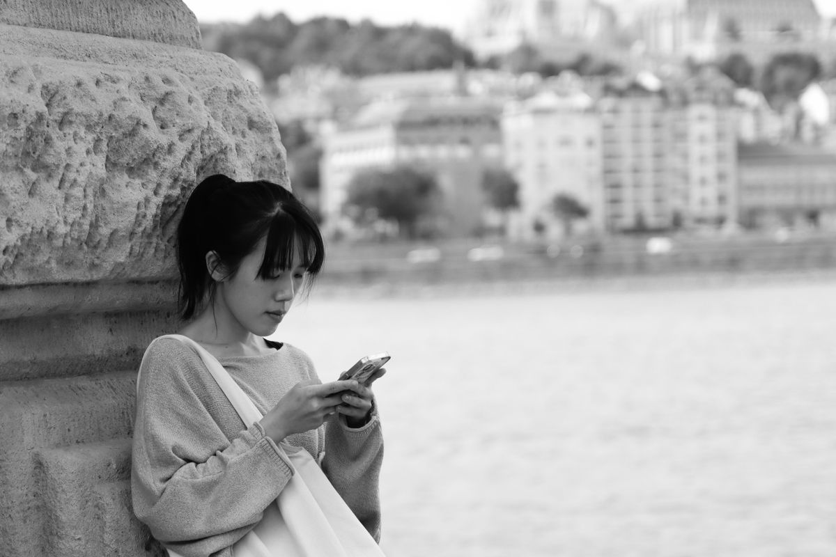 Voyageuse utilisant son smartphone au bord du Danube à Budapest