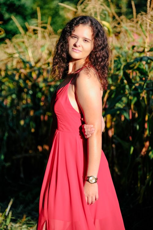 A Woman in Red Dress Smiling while Looking Over Shoulder Free Stock Photo A Woman in Red Dress Smiling while Looking Over Shoulder Free Stock Photo